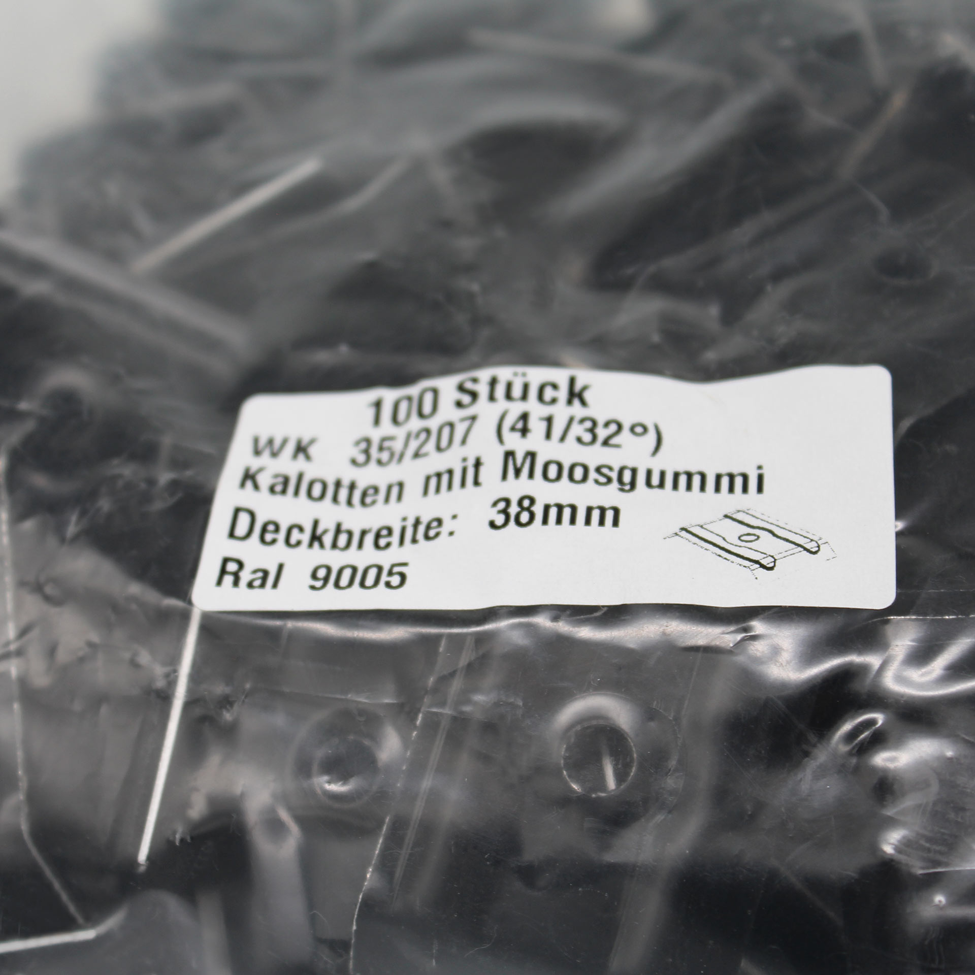 Verpackung mit Kalotten in schwarz. Auf dem Aufkleber steht der Inhalt und technische Daten.